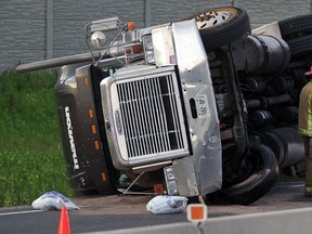 Tecumseh firefighters on west bound 401 near Hwy. 3 following a rollover where a 18-wheeler lost control Wednesday July 10, 2013.  The driver was not injured and traffic was down to one lane for several hours. (NICK BRANCACCIO/The Windsor Star)