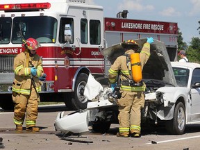 Lakeshore firefighters check out a damaged Ford Mustang, Thursday, July 11, 2013, in the westbound lanes of Highway 401 east of Manning Road. The car rear-ended an SUV. Injuries were minor. Traffic in the area was queued up for kilometres as the highway was shut down at Manning due to an earlier accident in the day.  (DAN JANISSE/The Windsor Star)