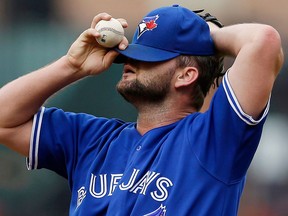 Blue Jays starting pitcher Todd Redmond pauses to adjust his cap between pitches in the fourth inning against the Baltimore Orioles Saturday, (AP Photo/Patrick Semansky)