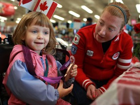 Zaena Johnsson, left, checks out one of Virginia McLachlan's two bronze medals from the Paralympics. (DAX MELMER/The Windsor Star)