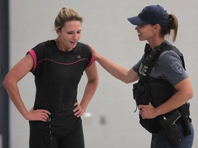 The Windsor Police Service gave over 50 local women a taste of the physical attributes a prospective officer requires Monday, June 17, 2013, at the Tilston Armouries in Windsor, Ont. Nicole Peltret, 24, left, gets a pat on the back from Const. Patti Pastorius after participating in a physical endurance test.    (DAN JANISSE/The Windsor Star)