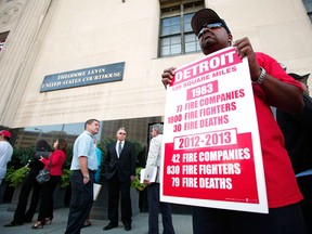 A member of Local 334 of the Detroit Firefighters Association protest outside during the City of Detroit's bankruptcy hearing at the U.S. Courthouse July 24, 2013 in Detroit, Michigan. Detroit is the largest city to file for bankruptcy in U.S. history and owes its approximately 100,000 creditors between $18 and $20 billion. (Photo by Bill Pugliano/Getty Images)