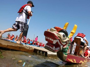 A paddler makes his way to his boat before competing in the International Dragon Boat Festival for the Cure in Tecumseh, Ont., Sunday, July 14, 2013.  (DAX MELMER/The Windsor Star)