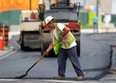 An employee with Coco Paving works on a hot morning, Monday, July 15, 2013, in downtown Windsor, Ont. A crew was repaving a section of road on Church Street near University Avenue. (DAN JANISSE/The Windsor Star)