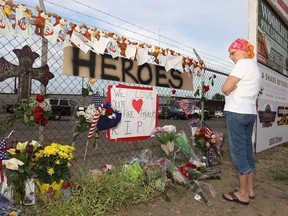 Judy Ostendorf of Prescott, AZ observes a memorial set up outside of Station 7 on July 1, 2013 in Prescott, Arizona. 19 firefighters based out of Station 7 died battling a fast-moving wildfire near Yarnell, AZ on Sunday. Station 7 has been the home of the Granite Mountain Interagency Hotshot Crew since 2010. GMIHC is a national resource that responds to wildland and all risk incidents in the Prescott Basin. (Photo by Christian Petersen/Getty Images)