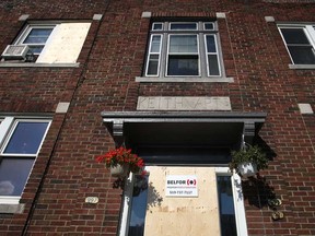 The front door and second-storey window are boarded up at an apartment complex at 987 Pierre Ave., in Windsor, Ont., after an early morning fire, Saturday, July 13, 2013.  This was the second fire at the complex in less than two weeks.  (DAX MELMER/The Windsor Star)