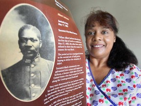 Christine Jackson holds a commemorative poster, Monday, July 8, 2013, at her Windsor, Ont. home of her great-grandfather Albert Jackson, Toronto's first black postman. The Canadian Union of Postal Workers is honouring him with the poster.    (DAN JANISSE/The Windsor Star)