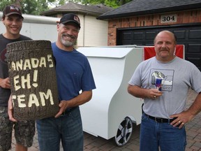 Members of the 'Eh Team' competing in the Red Bull Flugtag in Ottawa-Gatineau, are Ryan Martin, 22, left, Greg Martin, 52, and Paul Atherton, 45, standing in front of a section of their flying machine, Sunday, July 7, 2013.  (DAX MELMER/The Windsor Star)