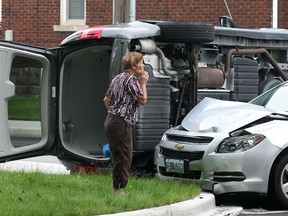 A woman checks out the scene of a two-car collision Friday, July 5, 2013, at the intersection of Janette Avenue and Elliot Street in Windsor, Ont. The accident occurred at 11 a.m. and resulted in minor injuries to one motorist. (DAN JANISSE/The Windsor Star)