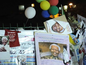 Balloons and portraits of former South African President Nelson Mandela are displayed on July 4, 2013, outside the MediClinic Heart Hospital where Mandela is hospitalized in Pretoria. During a nearly one month battle for his life in hospital, ailing South African icon Mandela has occasionally been uncomfortable but has not been in pain, his wife Graca Machel said. Doctors treating Mandela said he was in a "permanent vegetative state" and advised his family to turn off his life support machine, according to court documents dated June 26, obtained by AFP on July 4. (STEPHANE DE SAKUTIN/AFP/Getty Images)