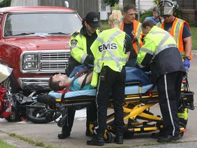 A motorcyclist suffered a broken leg Monday, July 22, 2013, after colliding with a truck at the intersection of Ypres Boulevard and Francois Road. The accident occurred shortly after 11 a.m. The motorcyclist is loaded onto a stretcher at the scene. (DAN JANISSE/The Windsor Star)