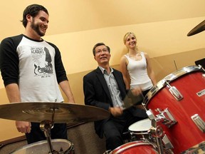 David Allen, left, and Siera Simoni, right, give Michael Chan, Minister of Tourism, Culture and Sport, a drum lesson during a tour of the Jam Space in Windsor on Thursday, July 25, 2013.              (TYLER BROWNBRIDGE/The Windsor Star)