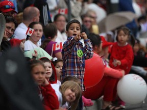 Children wait to see what's coming next as they watch the 2013 Canada Day Parade make its way down Wyandotte Street East in Windsor, Ont., Monday, July 1, 2013.  (DAX MELMER/The Windsor Star)