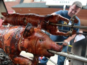 Alexander Konakov helps prepare a pig roast outside of Bobcats Sports Bar and Grill on Wyandotte Street East, Sunday, July 28, 2013.  Boban Stojkovski, the owner of Bobcats, is donating all proceeds from the pig roast to the Windsor Youth Centre.  (DAX MELMER/The Windsor Star)