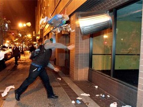 A man throws a trash can at the window of a building during a protest after George Zimmerman was found not guilty in the 2012 shooting death of teenager Trayvon Martin, early Sunday, July 14, 2013, in Oakland, Calif. Protesters angered by the acquittal Zimmerman held largely peaceful demonstrations in three California cities, but broke windows and started small street fires Oakland, police said. (Anda Chu, AP)