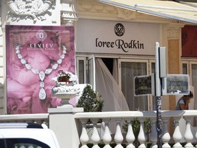 A French policeman, right, investigates outside the Carlton Hotel on July 28, 2013 in the French Riviera resort of Cannes, after an armed man held up the jewelry exhibition "Extraordinary diamonds" of the Leviev diamond house, making away with jewels estimated to be worth about 40 million euros ($53 million), according to investigators. The lone gunman managed to evade security and escape with a briefcase containing the valuable jewelry (VALERY HACHE/AFP/Getty Images)