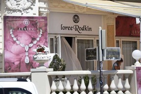 A French policeman, right, investigates outside the Carlton Hotel on July 28, 2013 in the French Riviera resort of Cannes, after an armed man held up the jewelry exhibition "Extraordinary diamonds" of the Leviev diamond house, making away with jewels estimated to be worth about 40 million euros ($53 million), according to investigators. The lone gunman managed to evade security and escape with a briefcase containing the valuable jewelry (VALERY HACHE/AFP/Getty Images)