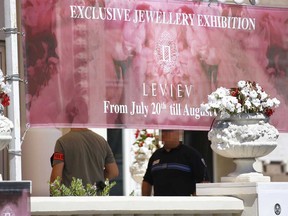 French policemen investigates outside the Carlton Hotel on July 28, 2013 in the French Riviera resort of Cannes, after an armed man held up the jewelry exhibition "Extraordinary diamonds" of the Leviev diamond house, making away with jewels now estimated to be worth about  $136 million, according to investigators. The lone gunman managed to evade security and escape with a briefcase containing the valuable jewelry (VALERY HACHE/AFP/Getty Images)