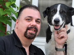 Mike Lambros of Windsor, Ont., is shown Tuesday, July 2, 2013, with his new best friend, Tommy, a dog rescued from Lebanon.  (NICK BRANCACCIO/The Windsor Star)