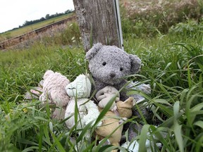 Teddy bears and flowers mark the scene of a tragic train crossing accident in Lakeshore, Ont. on Wednesday, July 31, 2013. Andrew Williams drove a van across the set of tracks on Strong Road with his four children travelling as passengers. Two of the children were killed when the van was struck by a train. Williams now faces criminal charges related to the accident.             (TYLER BROWNBRIDGE/The Windsor Star)