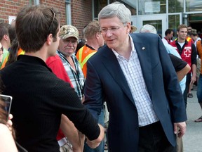 Prime Minister Stephen Harper meets residents Sunday, July 7, 2013 in Lac Megantic, Que., while visitng the emergency centre the day after a train derailed causing explosions of railway cars carrying crude oil. (THE CANADIAN PRESS/Paul Chiasson)