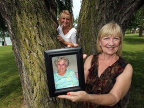 Maureen Jullion and Carol Tingle, right, both daughters of Jeannette Campeau, share some memories Friday, July 5, 2013, at the willow tree their mother and father planted in 1953.  Jeannette Campeau died Wednesday.  (NICK BRANCACCIO/The Windsor Star)