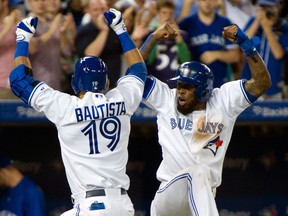 Toronto's Jose Reyes, right, congratulates Jose Bautista after the two scored on Bautista's homer off Tampa Bay pitcher David Price during the third inning Friday in Toronto. (THE CANADIAN PRESS/Frank Gunn)