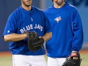Jays catcher J.P. Arencibia, left, talks with Pitcher R.A. Dickey during batting practice in Toronto. (THE CANADIAN PRESS/Chris Young)