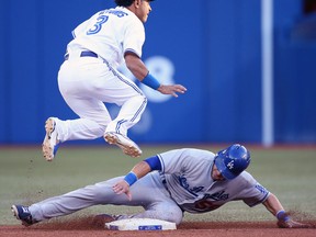 Skip Schumaker, bottom, of the Los Angeles Dodgers is forced out at second base as Maicer Izturis of the Toronto Blue Jays turns a double play at Rogers Centre. (Photo by Tom Szczerbowski/Getty Images)