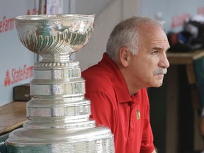 Chicago Blackhawks coach Joel Quenneville of Riverside sits in the Cubs dugout next to the Stanley Cup before throwing out a ceremonial first pitch against the Pittsburgh Pirates. (AP Photo/Nam Y. Huh)