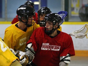 Windsor's Lucas Ducharme, right, is checked by teammate Logan Holmes, left, during practice at Forest Glade Arena Tuesday. (NICK BRANCACCIO/The Windsor Star)