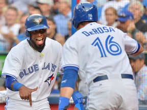 Toronto shortstop Jose Reyes, left, celebrates after scoring a run with teammate Mark DeRosa against the Detroit Tigers in the first inning Tuesday. (THE CANADIAN PRESS/Nathan Denette)