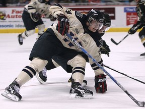 Spits forward Tom Kuhnhackl, left, drives to the net against London's Scott Harrington at the WFCU Centre. (DAN JANISSE/The Windsor Star)