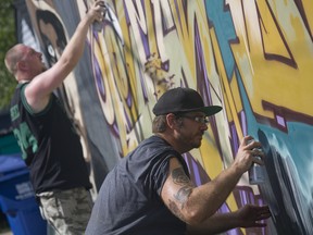 In this file photo, Scarborough artist "Lewter" (left) and Toronto artist "Sizeo" spray paints a wall at the 11th annual Walkerville Art Walk and Rock Saturday, July 20, 2013. Locall artist Daniel Bombardier and his Free For All Walls project is funded by the Ontario Trillium Foundation to bring talented artists from across the world to Windsor. (JOEL BOYCE / The Windsor Star)