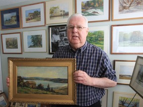 Stan Bergeron stands with his collection of paintings by W.F. Stidworthy in his Windsor apartment. (JASON KRYK / The Windsor Star)