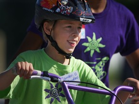 Camden Candless, 9, learns how to ride a two-wheel bike South Windsor Arena, Friday, July 12, 2013.  I Can Bike is a week-long camp that teaches kids with special needs how to ride a bike.  (DAX MELMER/The Windsor Star)