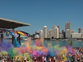 Runners toss coloured powder into the air at The Color Run's Finish Line Festival at the Riverfront Festival Plaza Saturday (DAX MELMER/The Windsor Star)