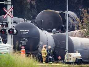 Firefighters speak at the scene of the explosion in the town of Lac-Mégantic, 100 kilometres east of Sherbrooke on Monday, July 8, 2013. A portion of a train carrying crude oil separated, derailed and exploded in the town of Lac-Mégantic on Saturday, July 6. (Dario Ayala / THE GAZETTE)