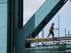 Carpenters from Local 494 and Steeplejack Services erect scaffolding around the base of the Ambassador Bridge on the Windsor side on Tuesday, July 30, 2013. The scaffolding is being installed for the upcoming painting.              (TYLER BROWNBRIDGE/The Windsor Star)
