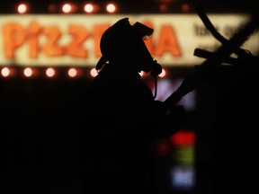 A firefighter is silhouetted in the Arcata Pizzeria sign as he battles a blaze at a commercial building at the intersection of West Grand Blvd and Dougall Ave. in this 2013 file photo. DAX MELMER/The Windsor Star)