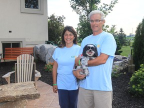 Mary Scerbo and Ernie Scerbo with pet dog Bender, stand at the serenity garden at their Leamington home on July 18, 2013.   In memory of their late son, they are  holding a fundraising walkathon at their residence on the weekend. (JASON KRYK/The Windsor Star)