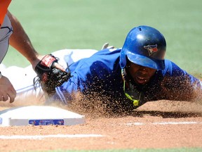Toronto's Jose Reyes, right, dives safely back into first base against the Houston Astros Sunday July 28, 2013 in Toronto. (THE CANADIAN PRESS/Jon Blacker)