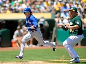 Toronto's Colby Rasmus , left, scores on a passed ball beating the throw back to Oakland pitcher Bartolo Colon July 31, 2013 in Oakland. (Thearon W. Henderson/Getty Images)