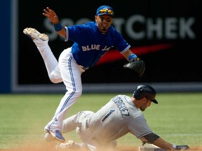 Blue Jays second baseman Maicer Izturis, left, turns a double play on Tampa Bay's Sean Rodriguez during the eighth inning in Toronto on Sunday, July 21, 2013. THE CANADIAN PRESS/Frank Gunn