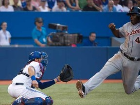 Tigers right fielder Torii Hunter, rigt, slides safe at home plate past Blue Jays catcher J.P. Arencibia in Toronto on Wednesday, July 3, 2013. THE CANADIAN PRESS/Nathan Denette