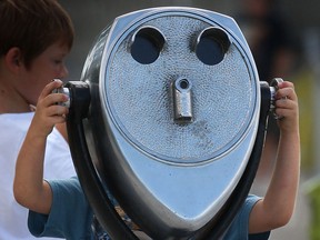 Looking a bit like an alien, a young boy checks out the sights along the Detroit River, Thursday, July 25, 2013, while visiting the Coventry Gardens in Windsor, Ont. (DAN JANISSE/The Windsor Star)