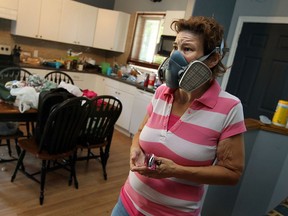 In this file photo, Cynthia Jamieson wears a mask while looking over her home after mould was discovered in the basement of the family home in South Windsor on Wednesday, July 24, 2013.              (TYLER BROWNBRIDGE/The Windsor Star)