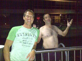 John Morillo (R) of Windsor and one of his fans, Markus Wolfstetter, on July 22, 2013, the night of Morillo's cross-border swim. Image provided by Markus Wolfstetter, who says it was taken at the riverfront railing of the GM Renaissance Center. (Handout / The Windsor Star)