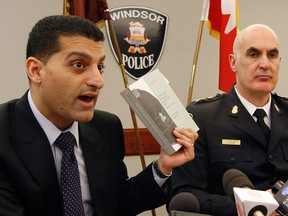 Windsor Mayor Eddie Francis, left, holds up a copy of the Police Services Act of Ontario while Chief of Police Al Frederick looks on in this January 2012 file photo. (Nick Brancaccio / The Windsor Star)