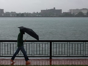 A man walks Windsor's riverfront barefoot in the rain in this file photo. (Dax Melmer / The Windsor Star)